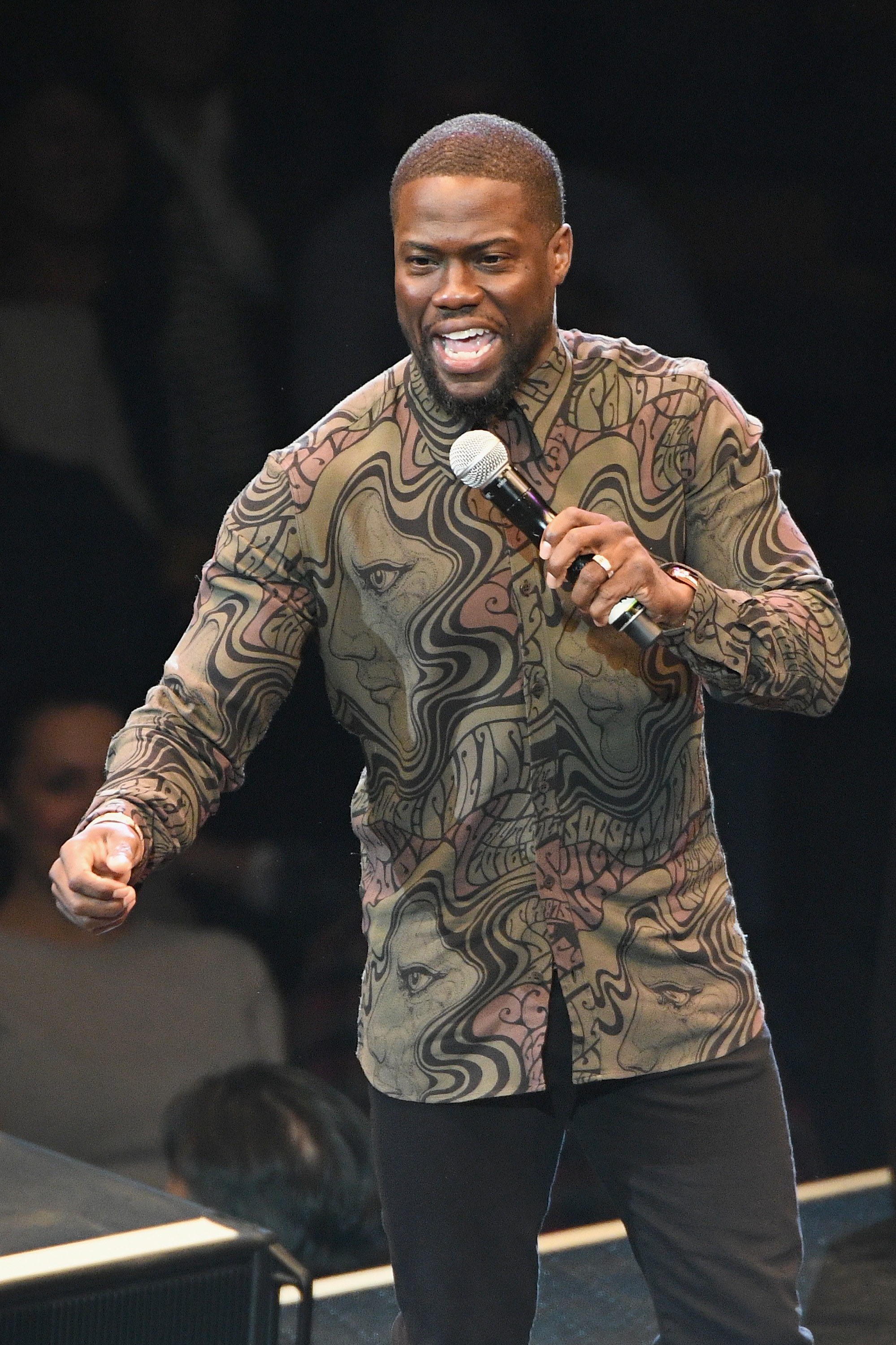 Kevin Hart performs stand-up onstage with a mic in hand