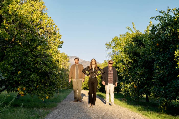 LILY COLLINS, JESSE PLEMONS and JASON SEGEL walk in an orange grove