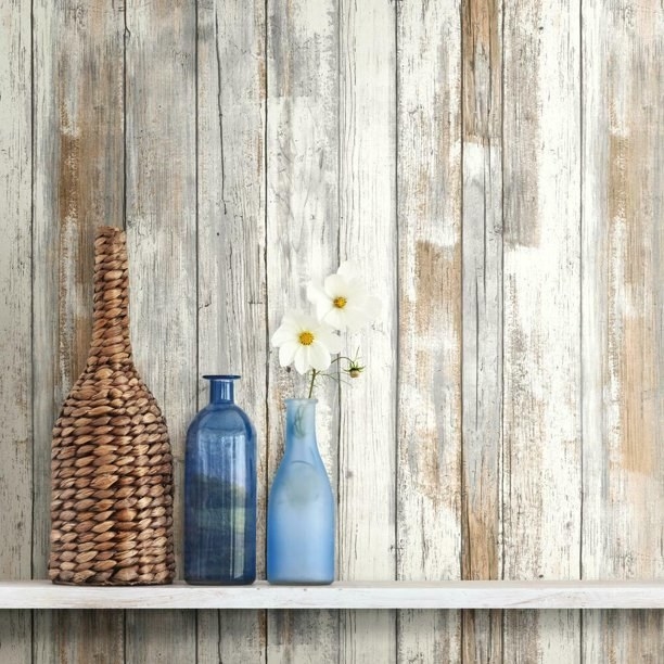 the distressed wood wallpaper behind a shelf with vases