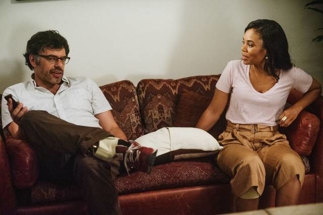 Jermaine Clement and Regina Hall sit on a couch