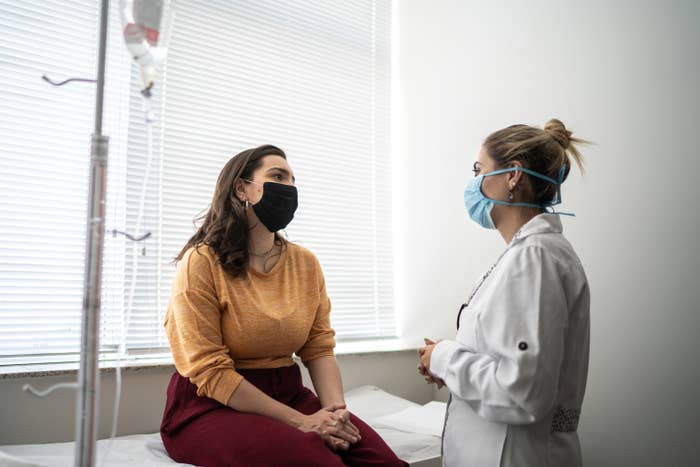Patient talking to doctor on medical appointment - wearing protective face mask