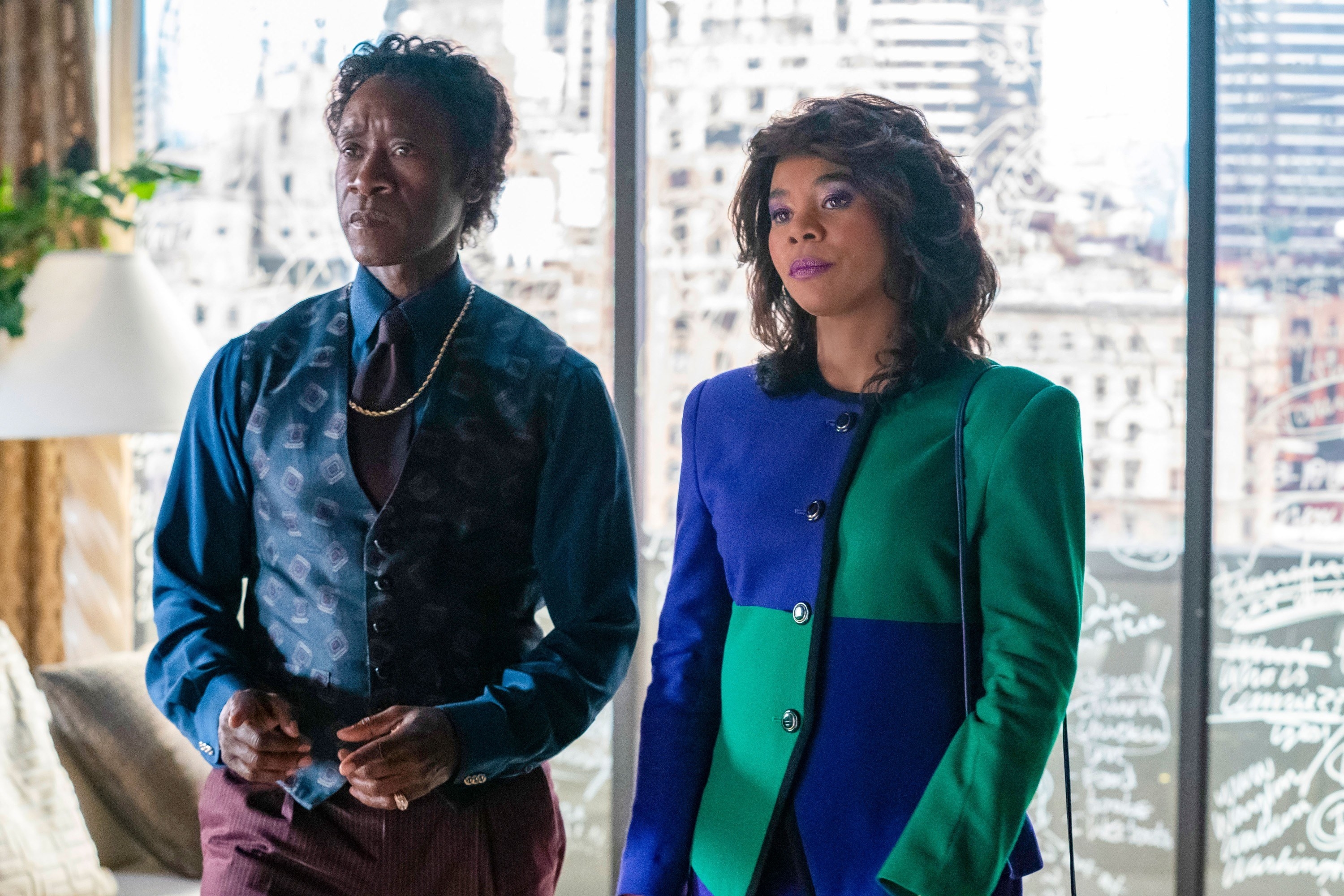Don Cheadle and Regina Hall stand in front of a window