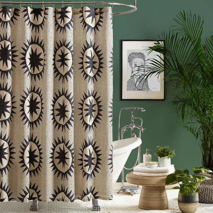 a white shower curtain with a dark grey solar quilt-like pattern