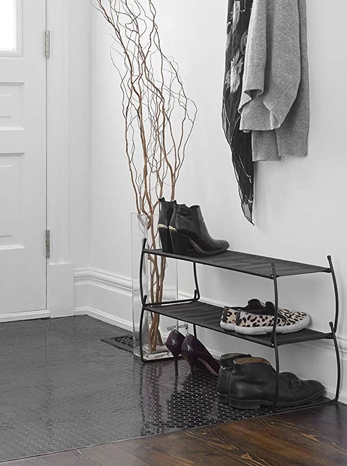 A shoe rack holding shoes by a front door