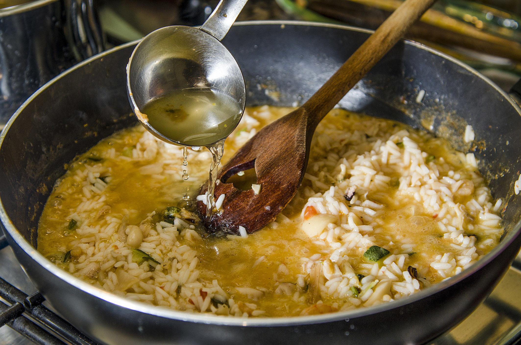 Pouring rice vinegar into risotto