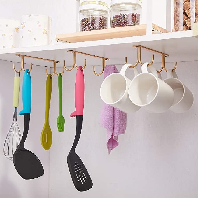 Mugs and cooking utensils hanging from the hooks