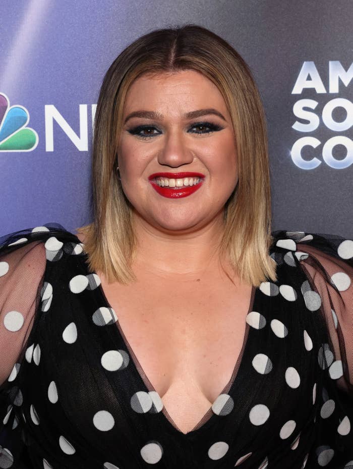 Kelly smiles at an event and rocks a polka dot outfit