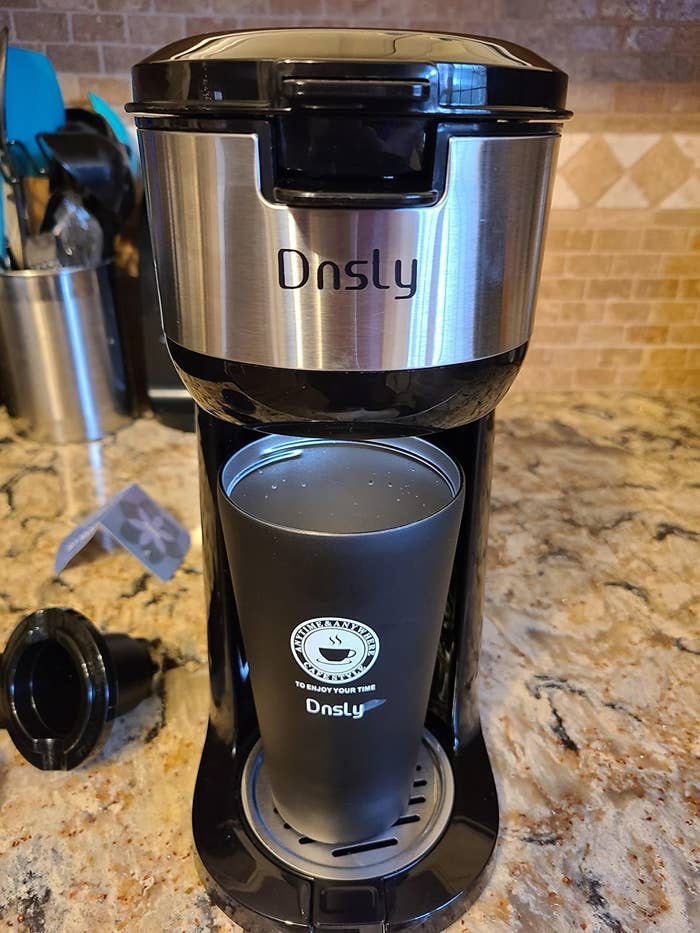 Reviewer photo of the coffee maker on a counter with a travel mug under the dispenser