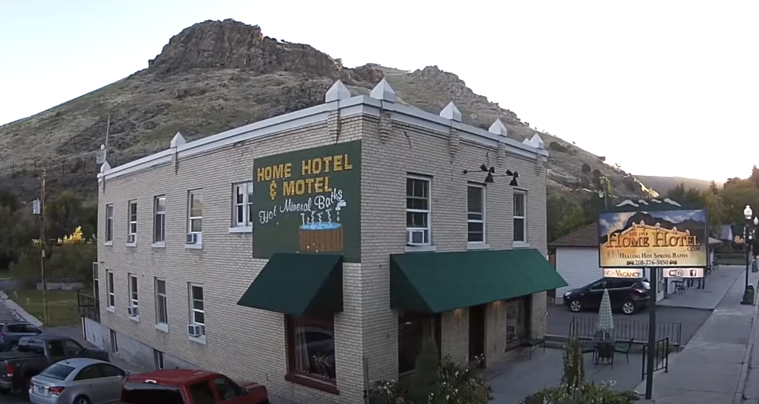 The exterior of the historic Home Hotel with a butte in the distance