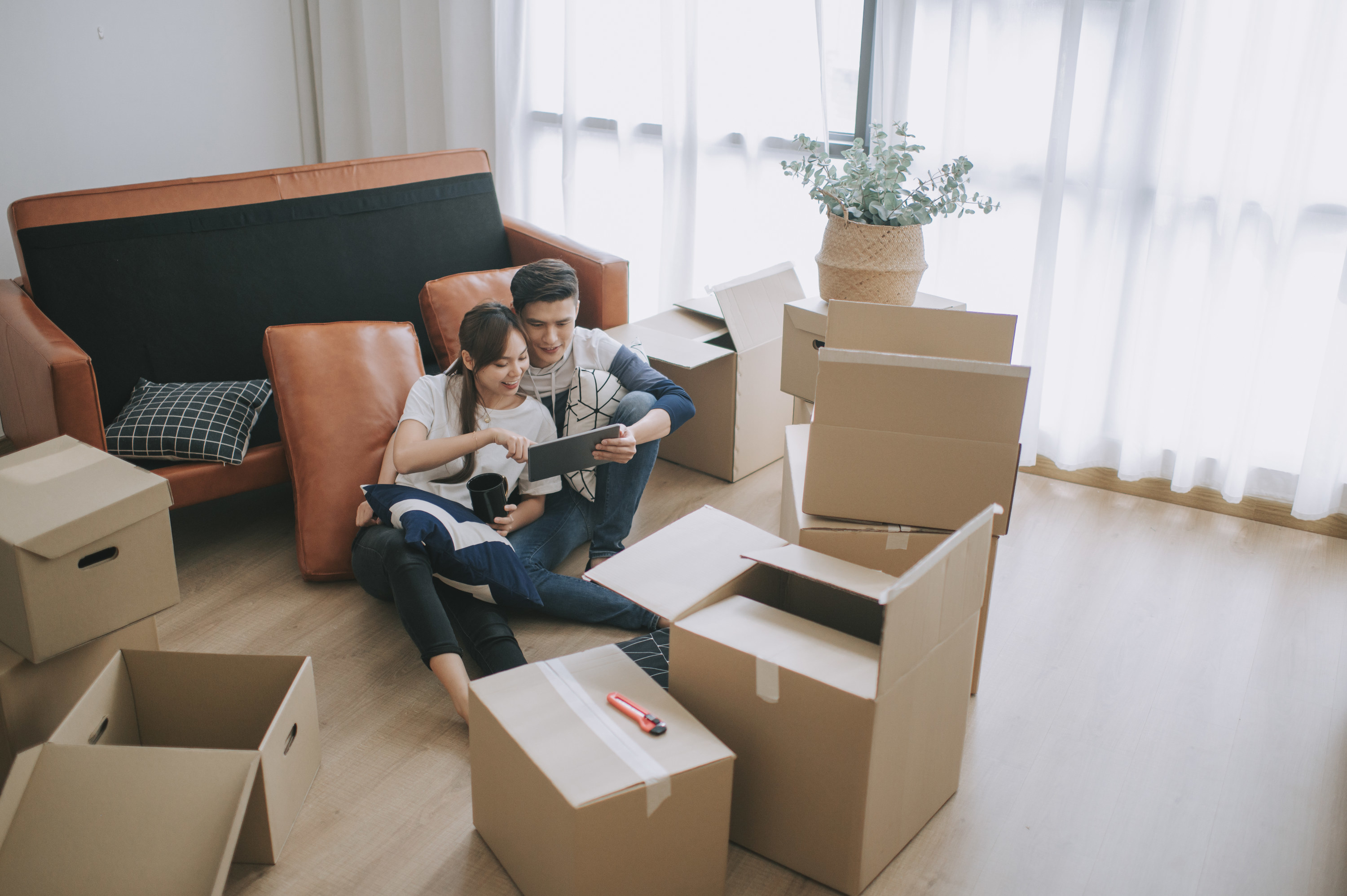 Couple surrounded by boxes in their new living room