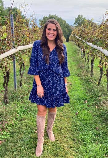 another reviewer wearing the blue ruffle dress in size medium out in a field