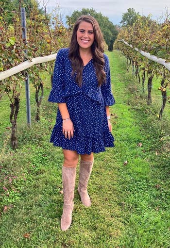reviewer wearing the blue ruffle dress in size medium out in a field