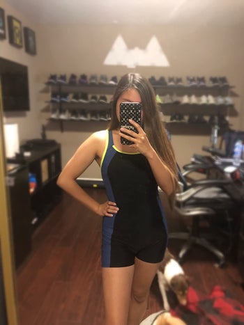 reviewer wearing the suit in black with blue stripe down the sides