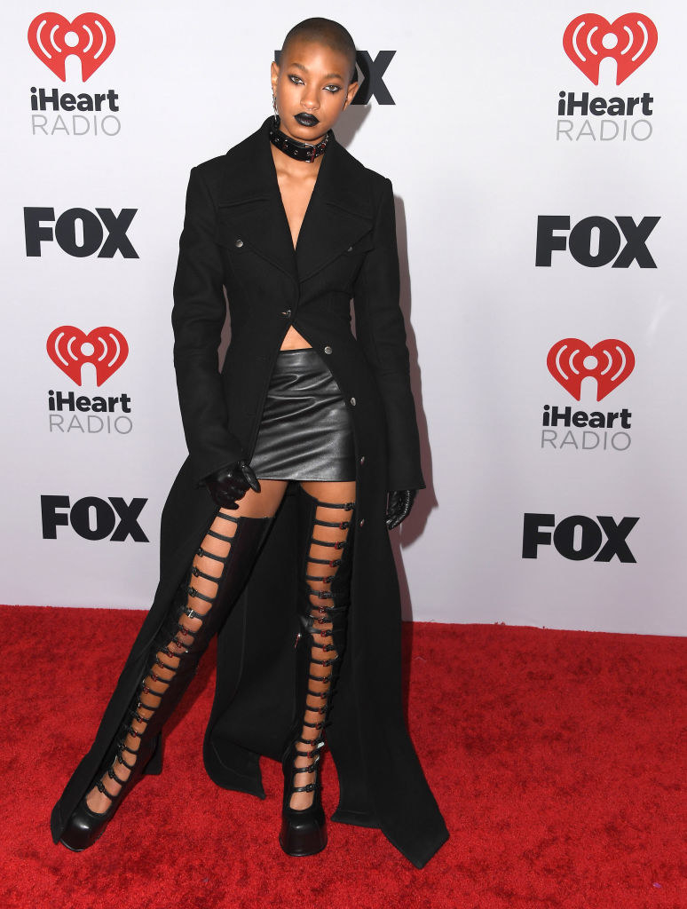 Willow in a floor-length suit dress, faux leather mini skirt, and thigh-high boots