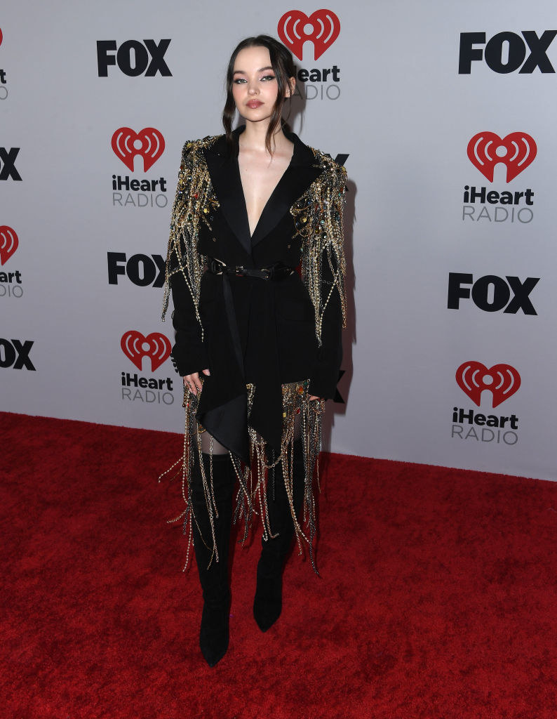 Dove in a bedazzled suit dress and over-the-knee boots