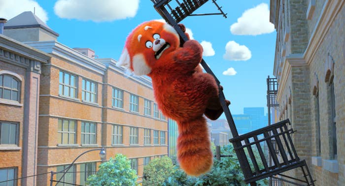 Mei as a giant red panda hanging off a metal balcony