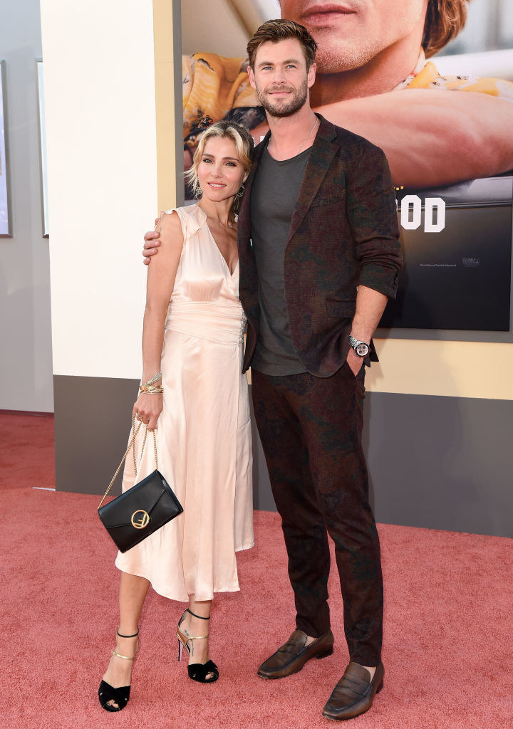 as they pose on the red carpet together, Elsa leans her head on Chris&#x27;s shoulder, and he puts his arm around her