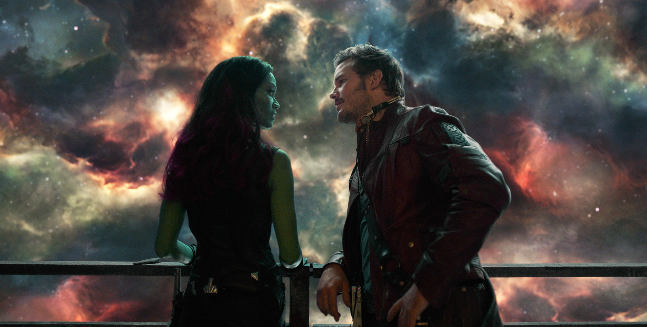 leaning against a railing, Gamora and Peter chat quietly