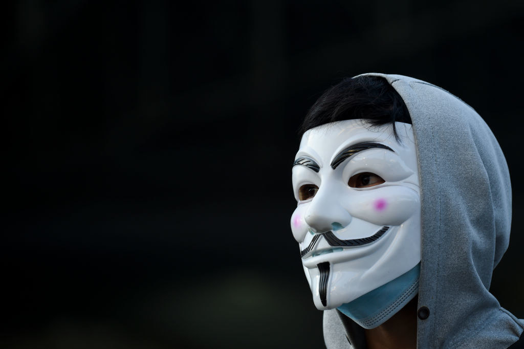 Person wearing a hoodie and anonymous Guy Fawkes mask