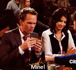 A close up of Barney Stinson as he slaps a hand away from his plate of fries and says, &quot;Mine&quot;