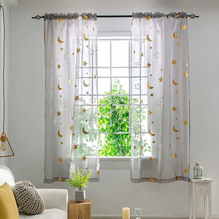 a pair of semi sheer curtains with a metallic starry pattern