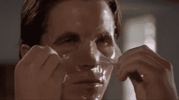 Christian Bale as Patrick Batemen in American Psycho peeling his face mask off