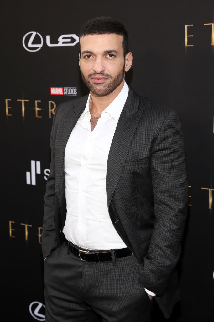 Haaz wears a simple suit and no tie on the red carpet