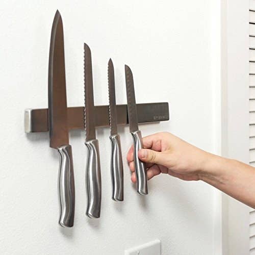 the magnetic knife holder with four stainless steel knives on it