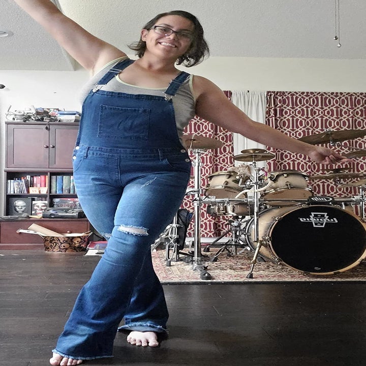 a reviewer wearing distressed overalls