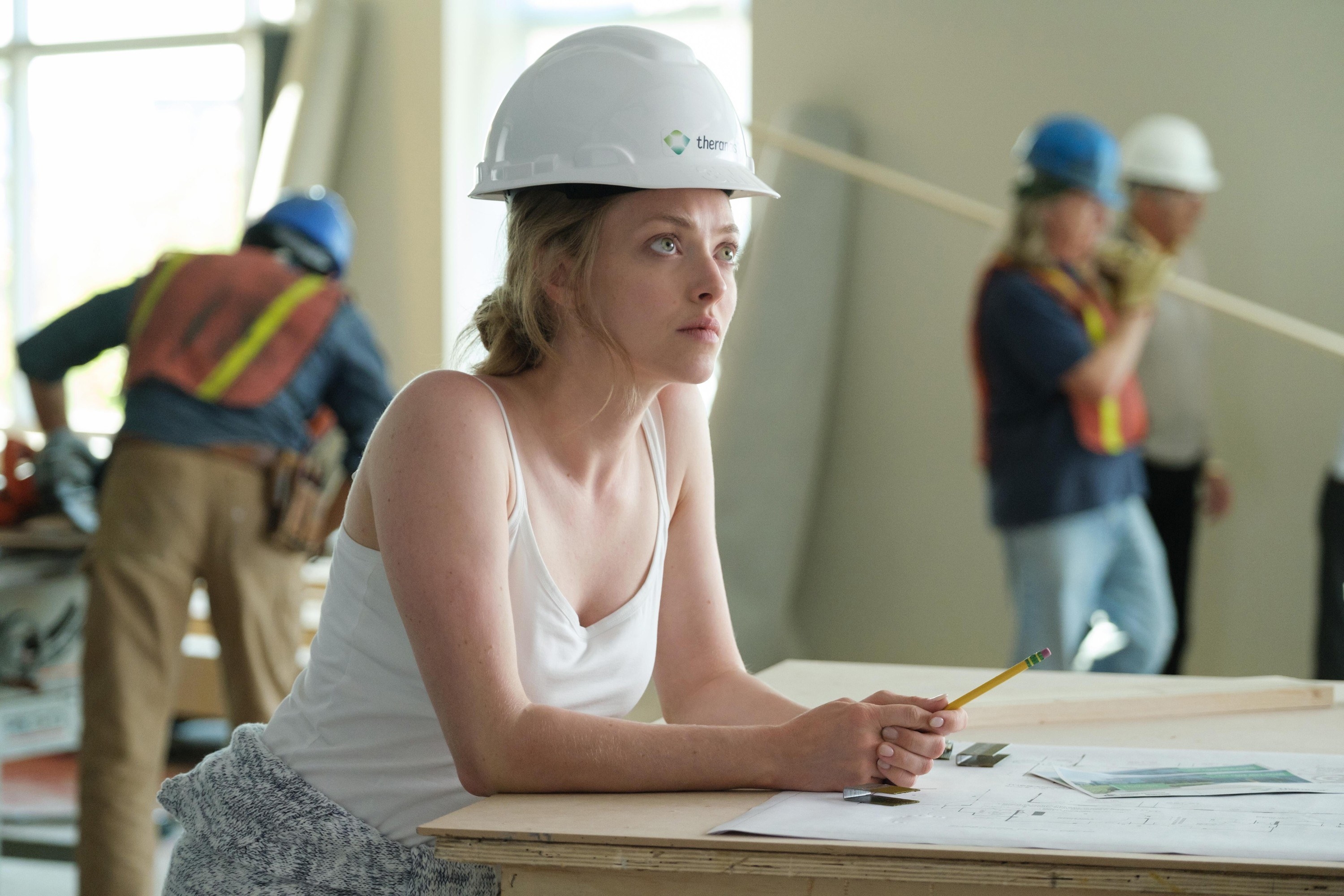 Seyfried looks up while wearing a hard hat