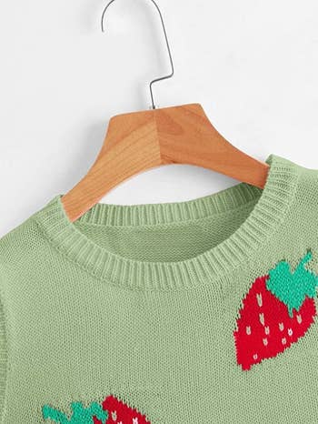 a close up of the sweater vest with strawberries