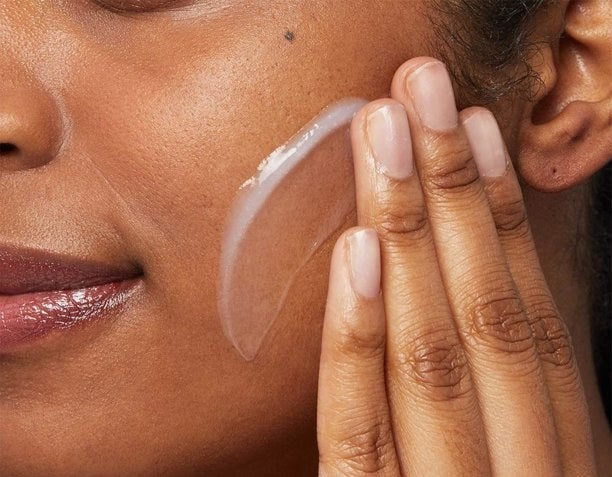 a model applying the cleanser to their skin