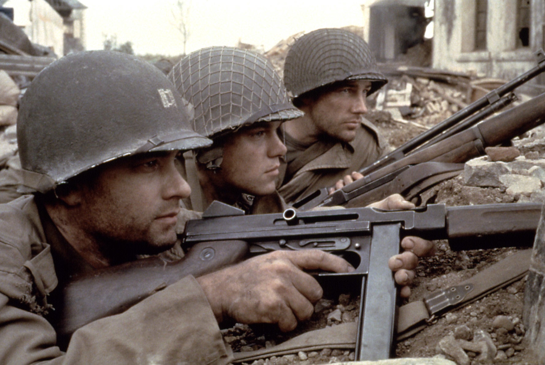 Three soldiers with guns raised prepare for combat