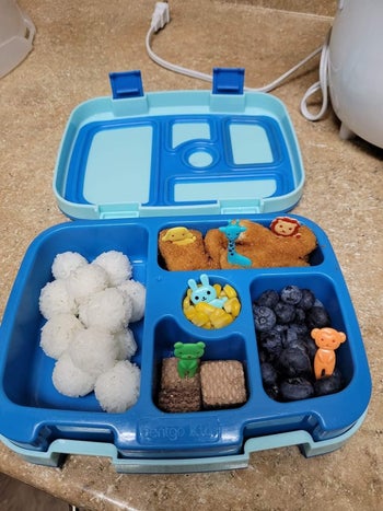 Reviewer's photo showing the animal-shaped food picks in their kid's lunchbox