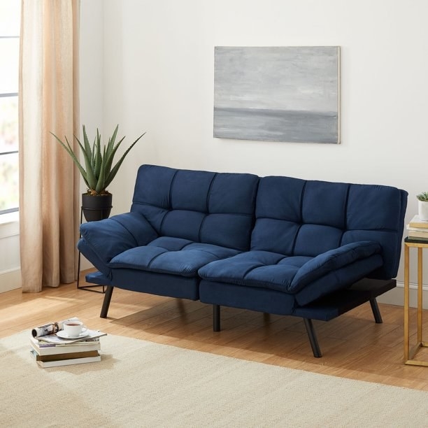 the navy futon staged in a living area