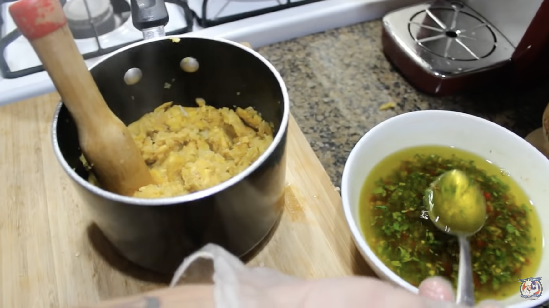 A pot of mofongo mixture and a bowl of seasoned oil next to it