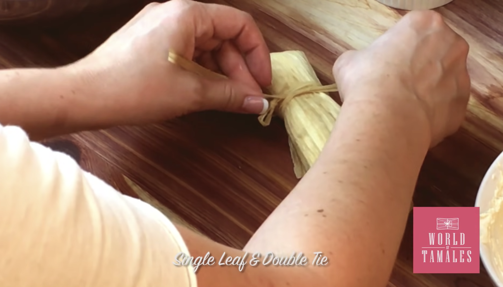 A tamale being tied with the words &quot;Single leaf and double tie&quot;
