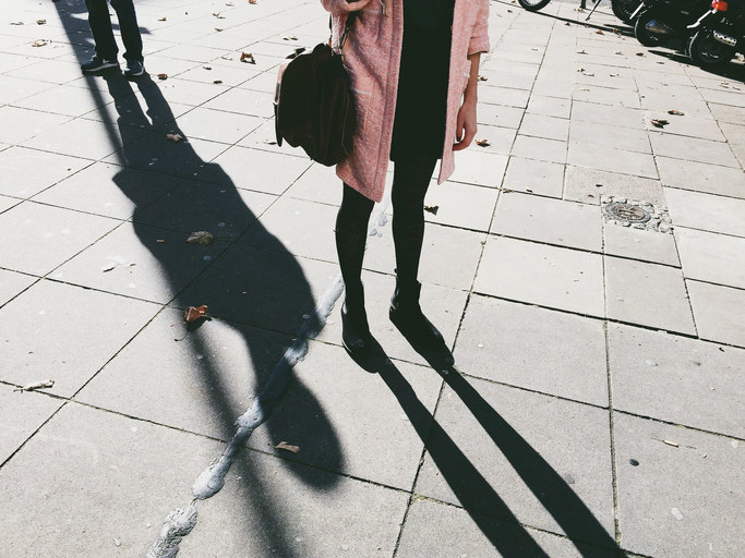 legs of a woman with a shadow creeping behind her
