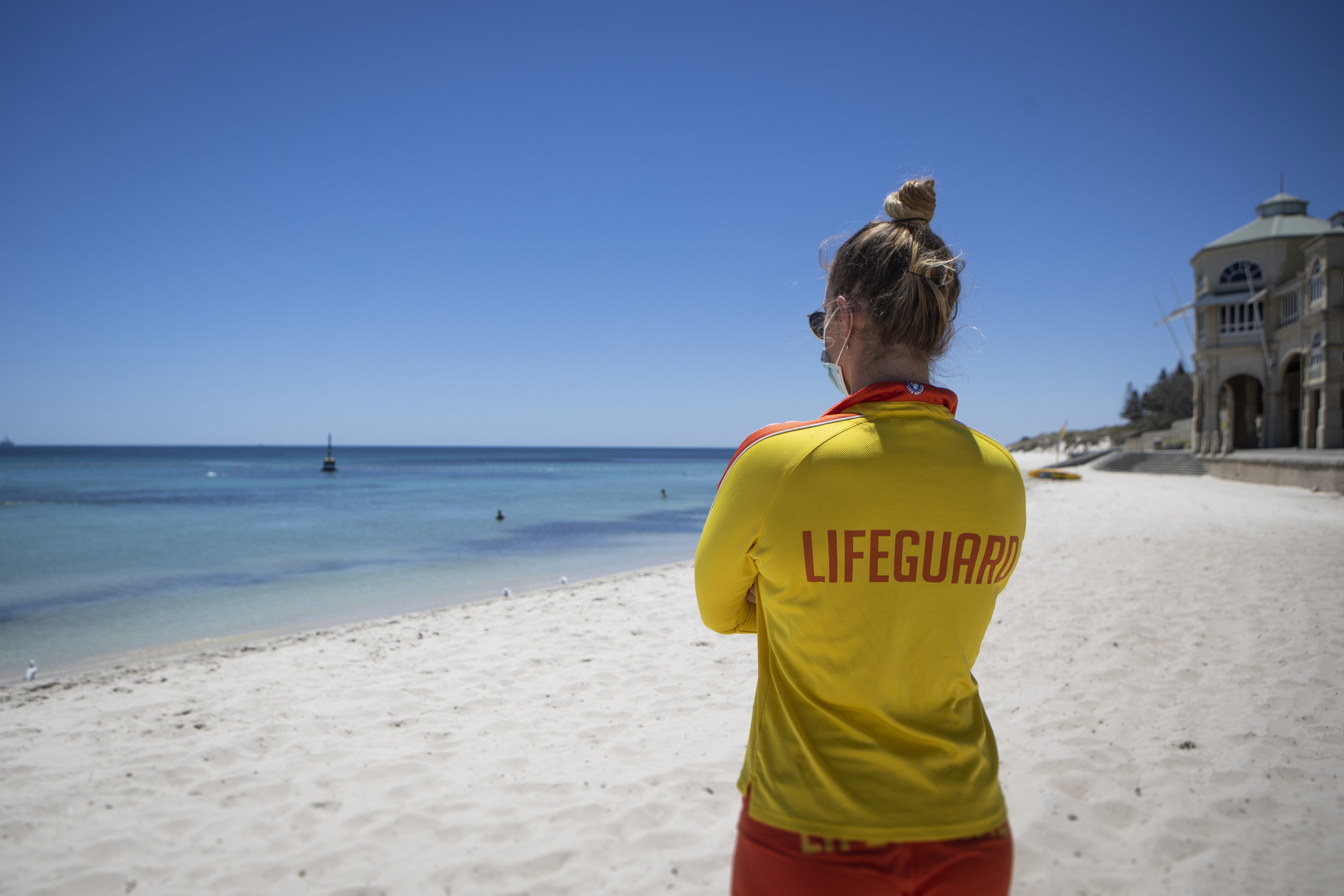 Lifeguard in yellow jacket watching over a beach