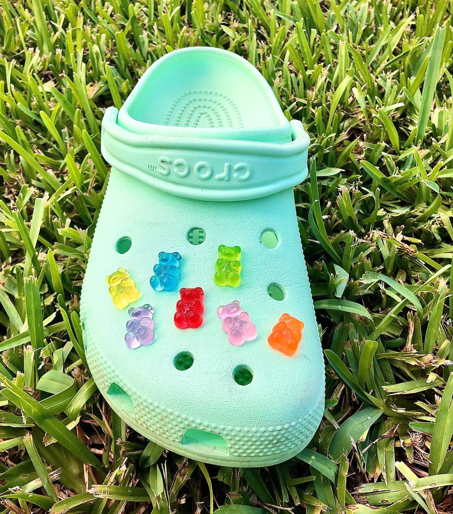 a green croc with seven different gummy bear charms