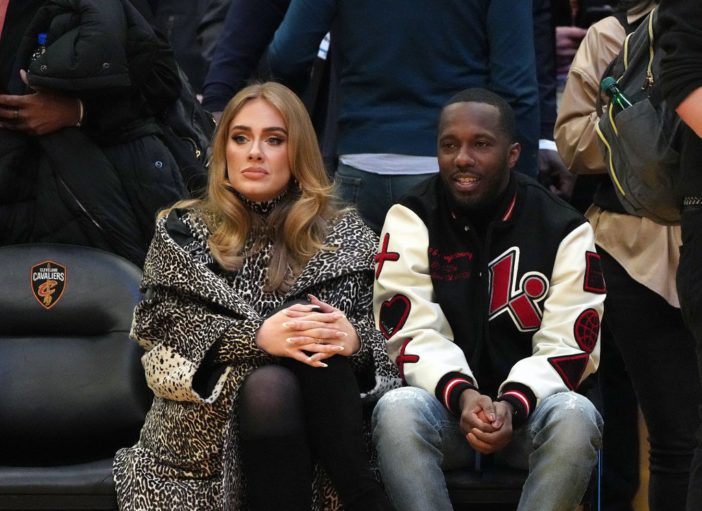 sitting side by side, the couple watches a basketball game