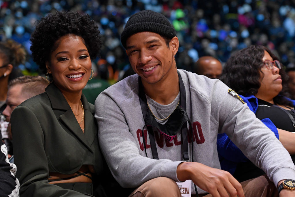 at a basketball game, Keke and Darius smile for a courtside picture
