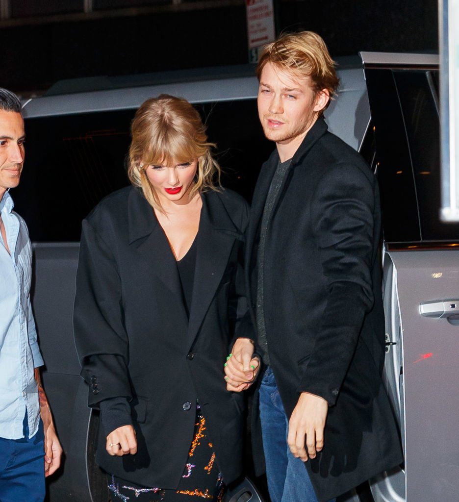 Joe and Taylor hold hands as they climb out of their car