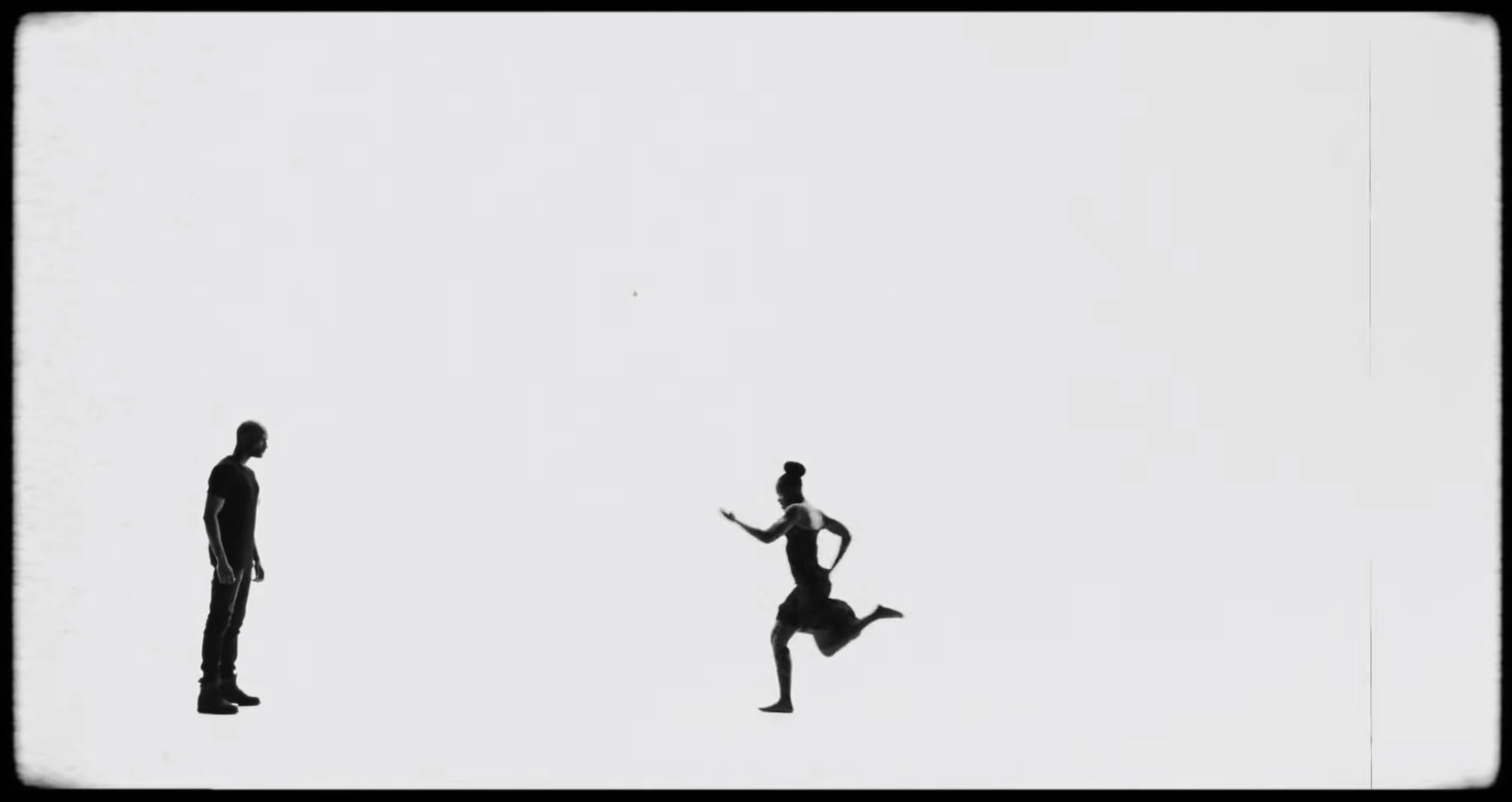 A woman running toward a man against a blank background