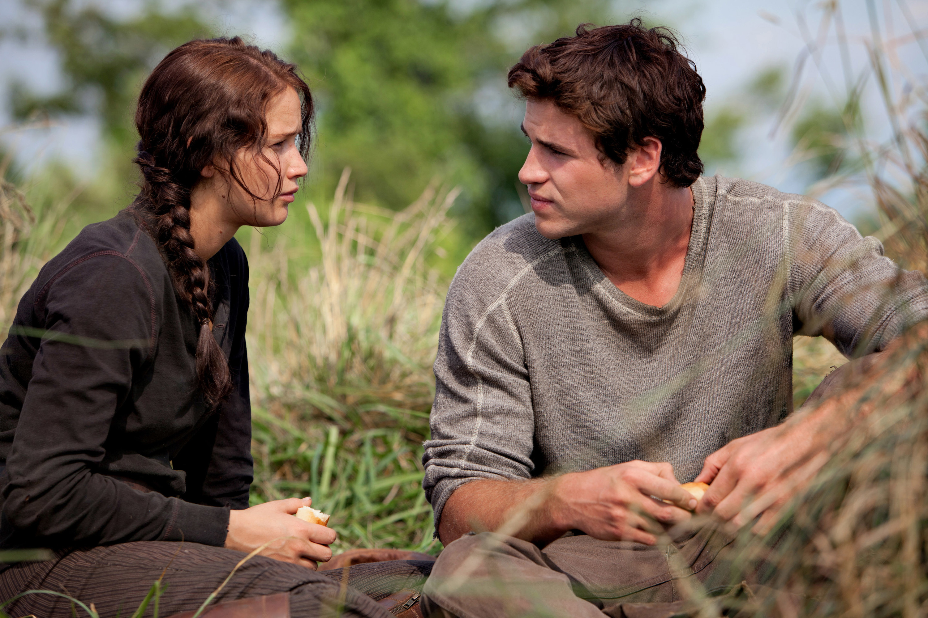 Katniss and Gale looking at each other in the grass