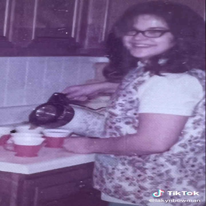 La abuela de Lakyn sonríe a la cámara mientras sirve té en tazas en la cocina.