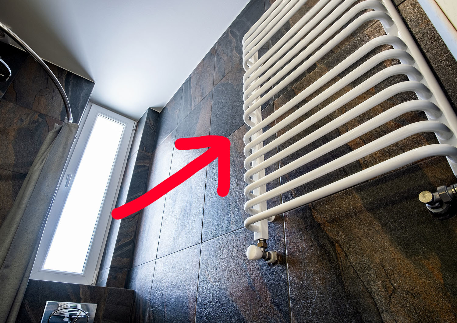 an arrow pointing to a ladder-like towel warmer