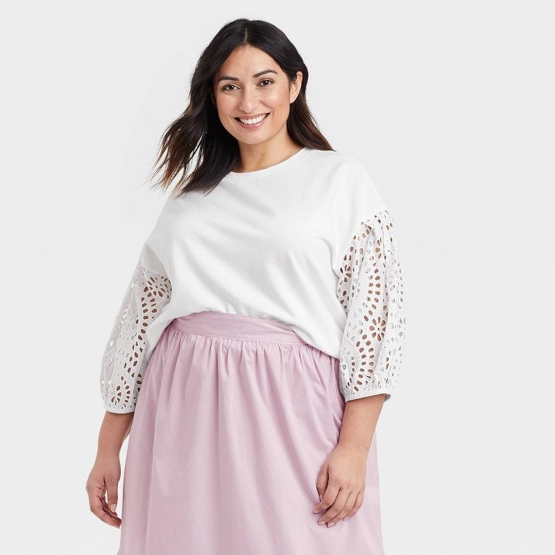 model wearing the shirt in white with a pink skirt