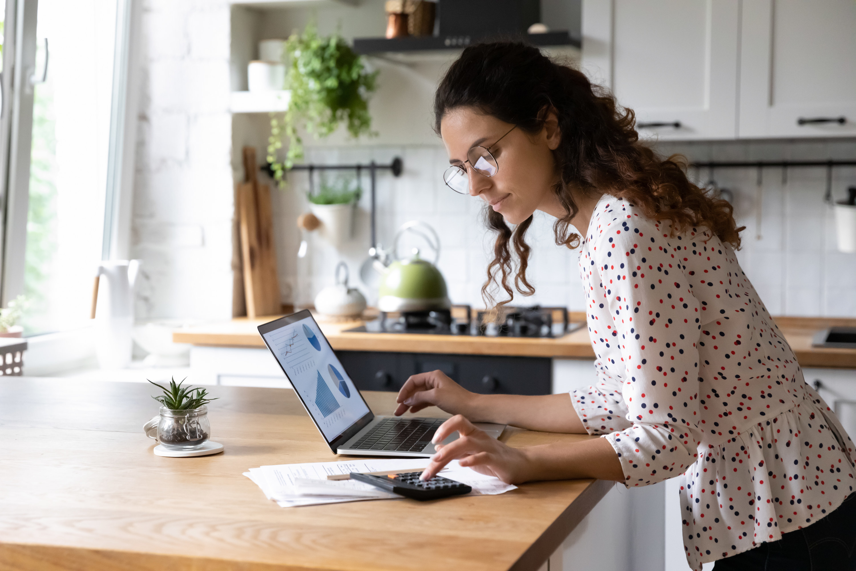 Woman looking at her computer and calculator