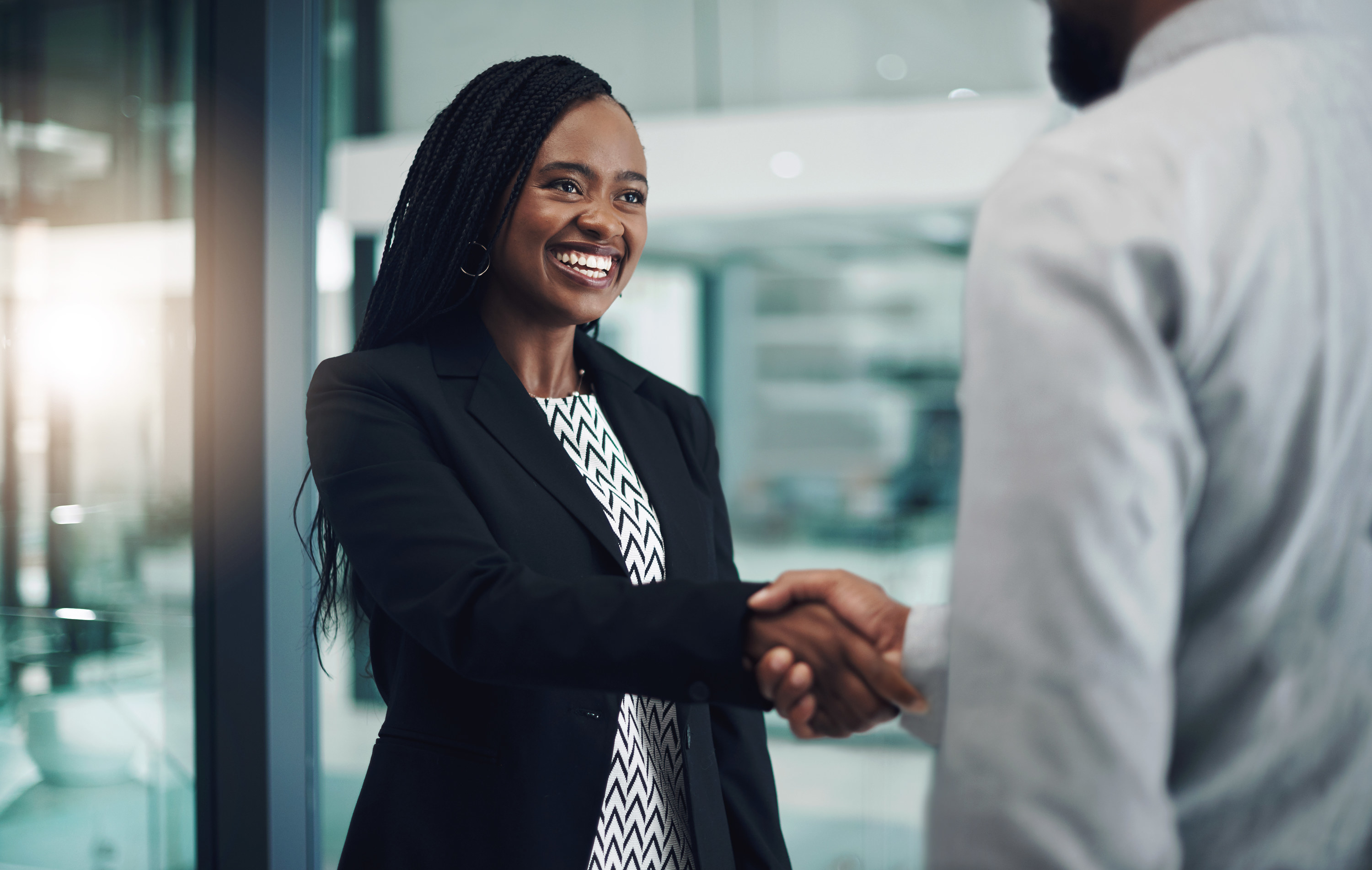 Woman in suit shaking someone&#x27;s hand